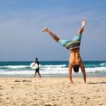 Mężczyzna w staniu na rękach na słonecznej plaży w Ustce